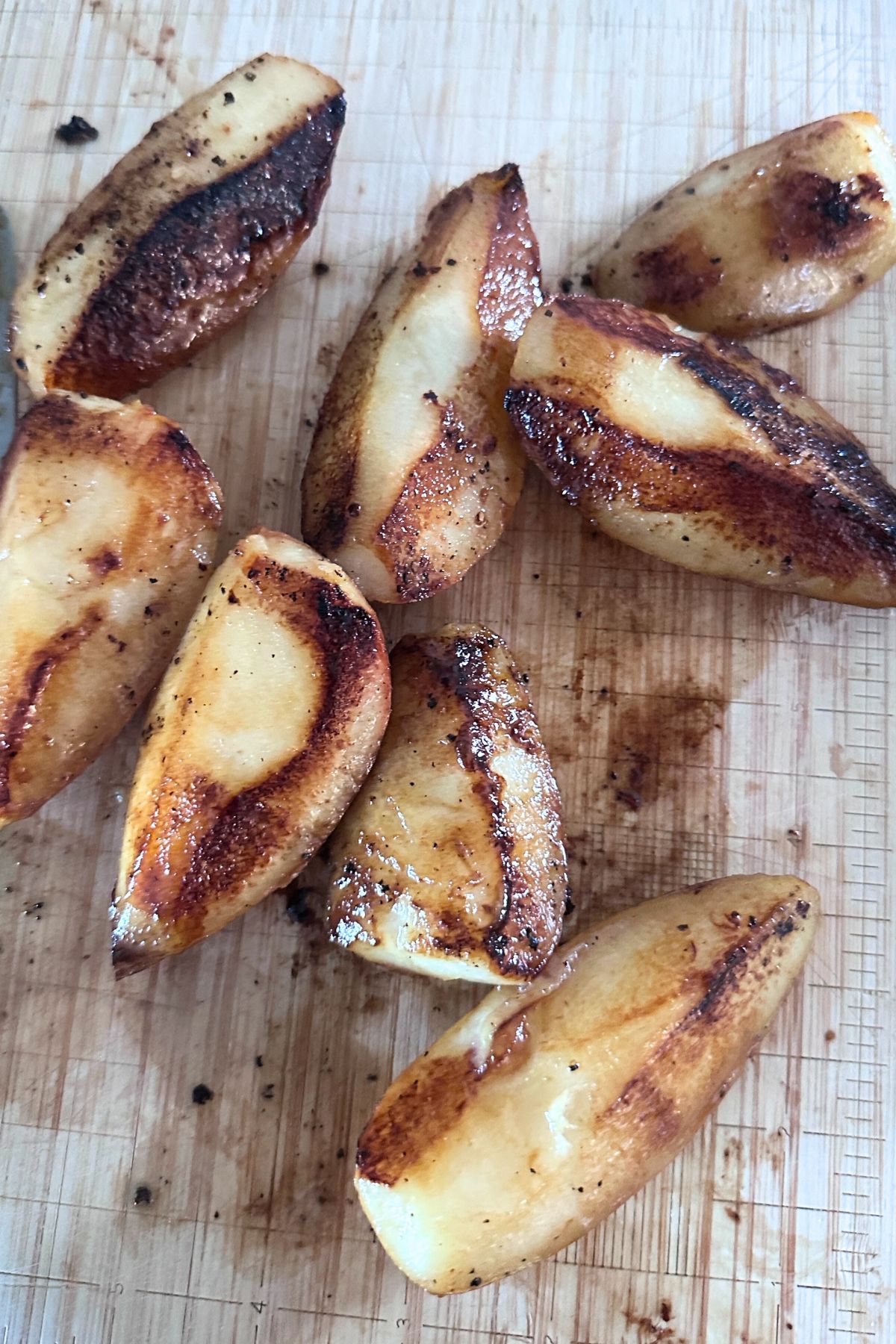 Quartered pears cooling on a cutting board.