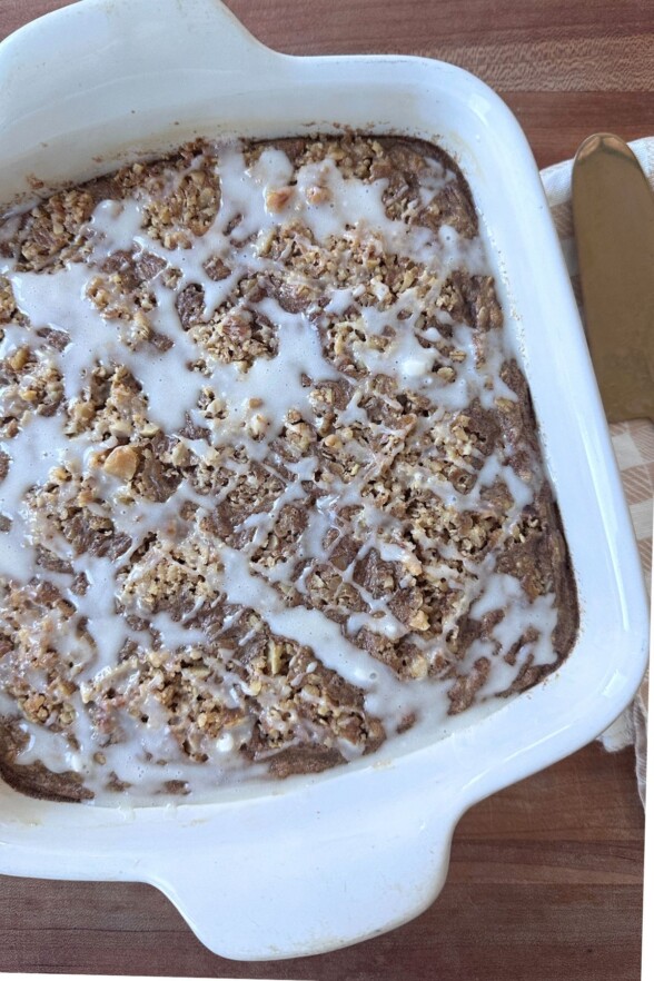 Coffee cake baked oatmeal in a baking dish drizzled with glaze.