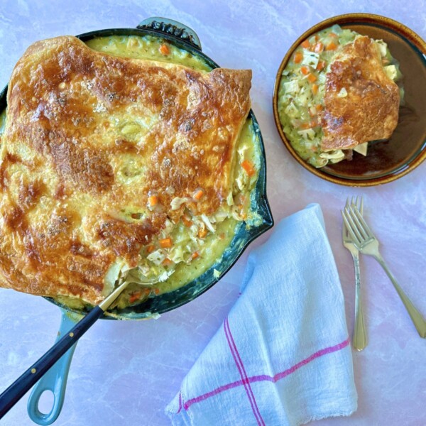 French chicken pot pie in a cast iron skillet on a white surface