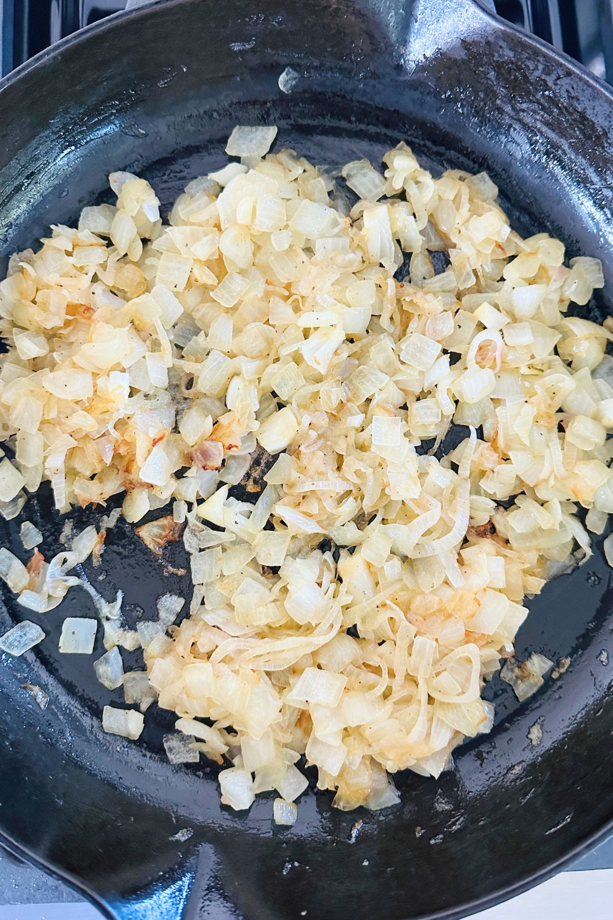 Olive oil, chopped onions, and shallots in a large skillet on the stove.