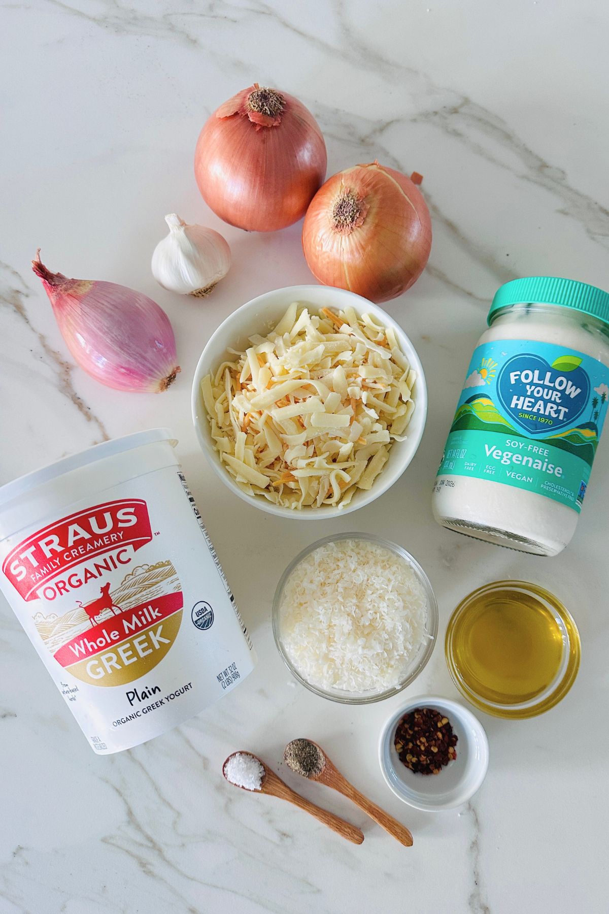 Ingredients for hot onion dip laid out on a white countertop.