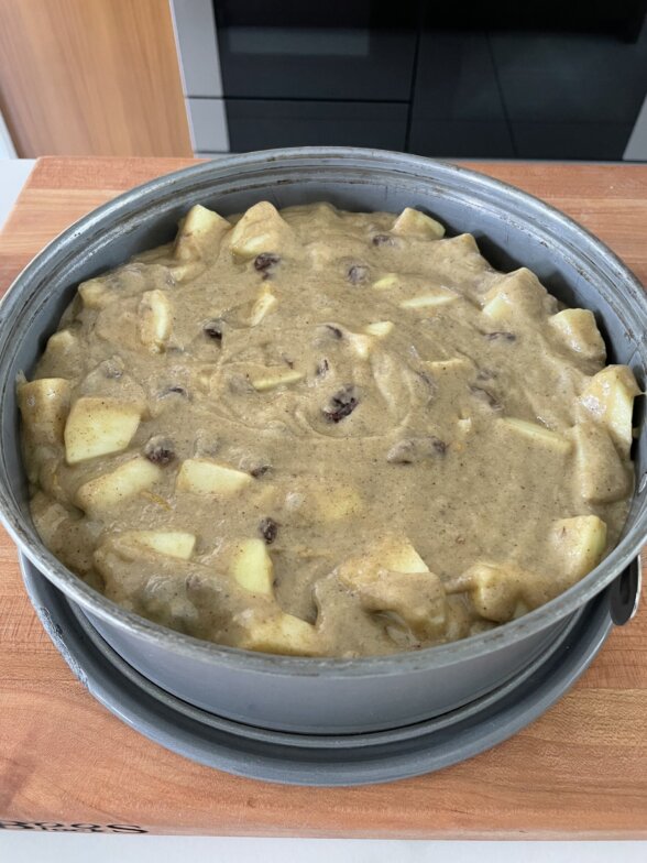 raw apple spice cake batter in a spring form pan 