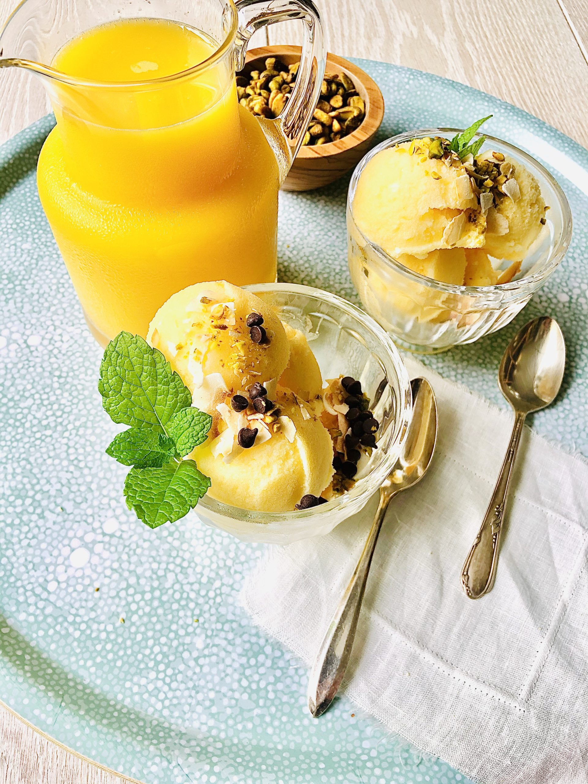 orange juice in a carafe next to 2 bowls of ice cream