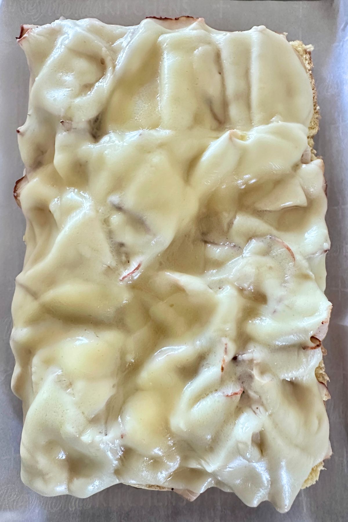 Melted provolone cheese over sliced turkey on soft slider rolls.