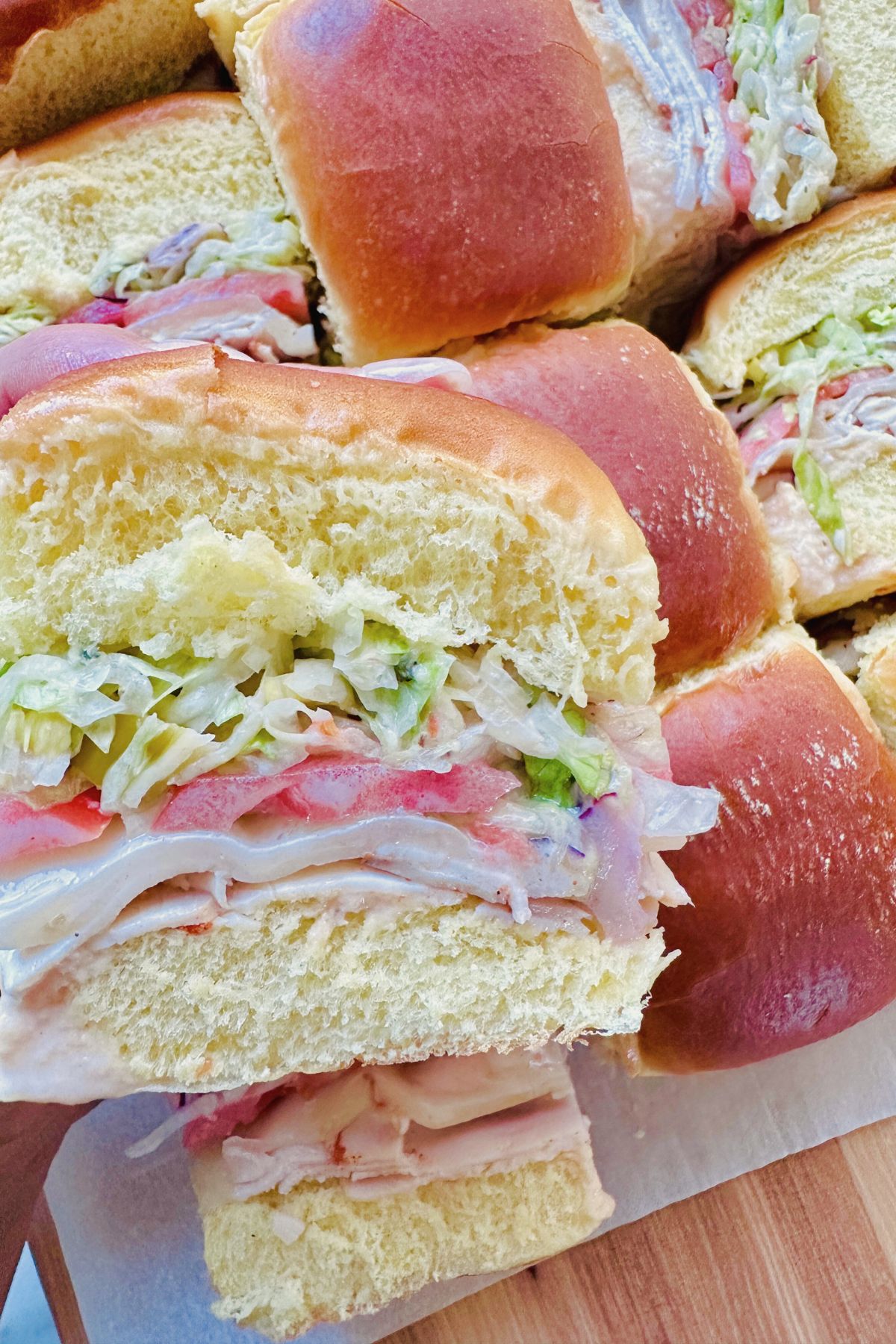 An Italian grinder slider lifted to show the layers inside the bun.