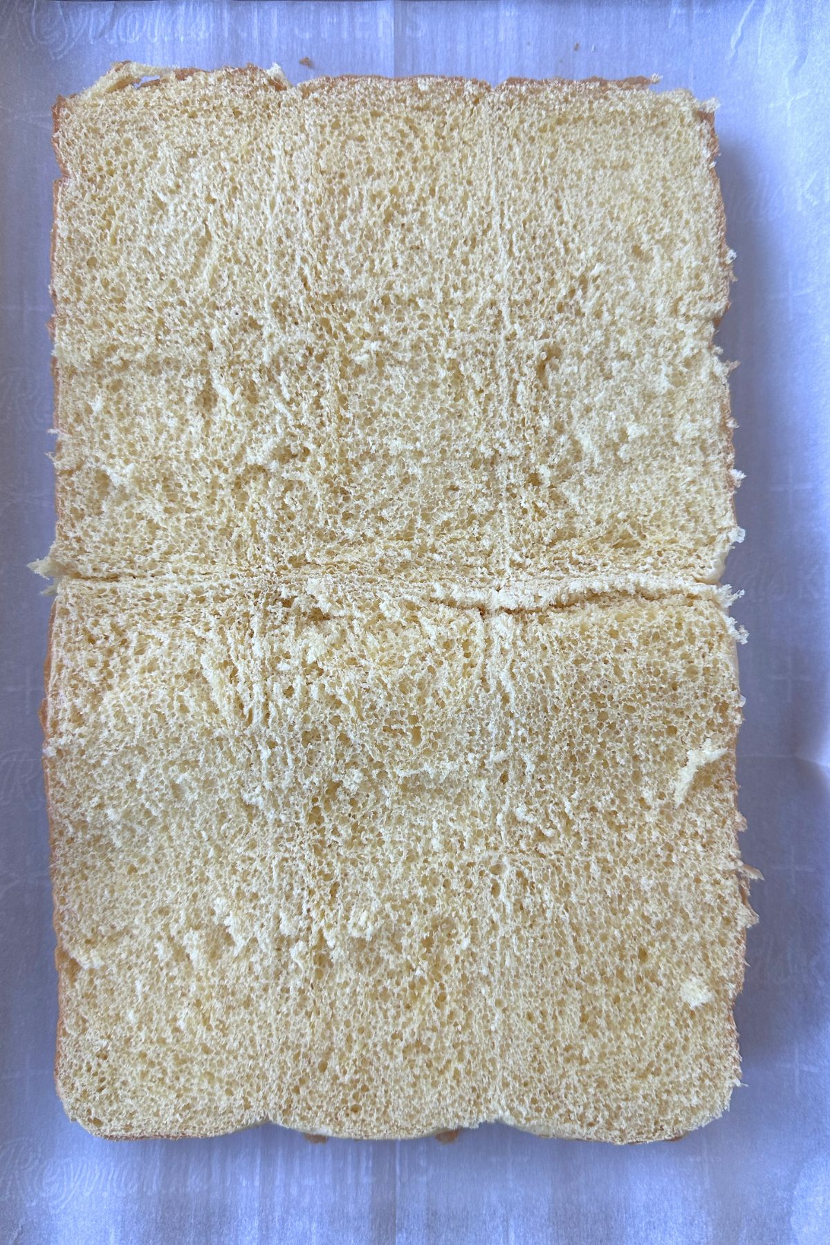 The bottom half of slider rolls on a prepared baking sheet, cut side up.