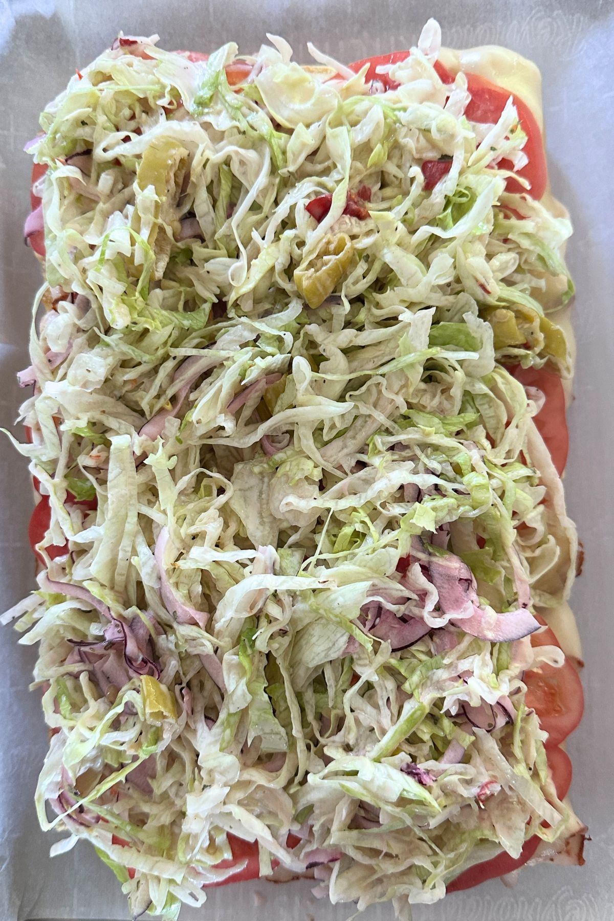 Warm sliders topped with tomato slices and dressed lettuce mixture.