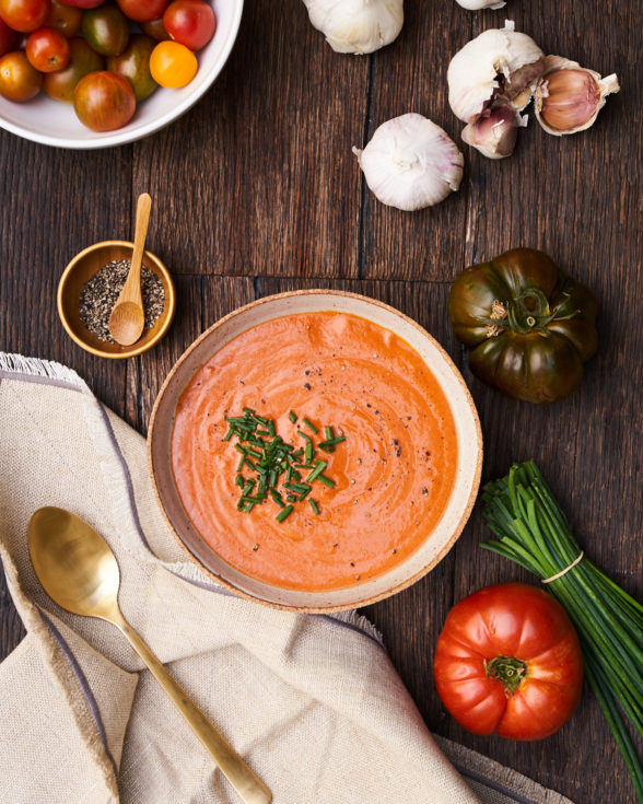 an overhead shot of salmorejo in a bowl next to ingredients 