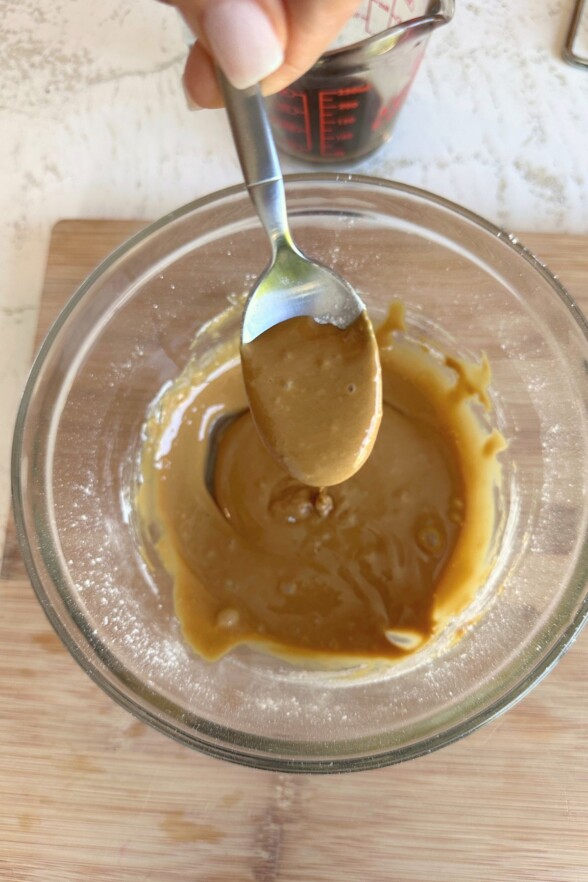 Glass mixing bowl with mixed coffee glaze, ready to drizzle over cake.