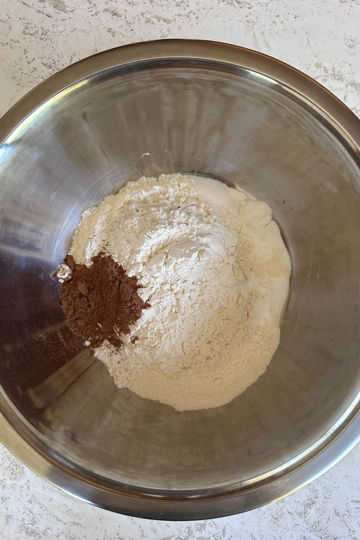 Combining cake dry ingredients -flours, baking soda, baking powder, and pumpkin pie spice.