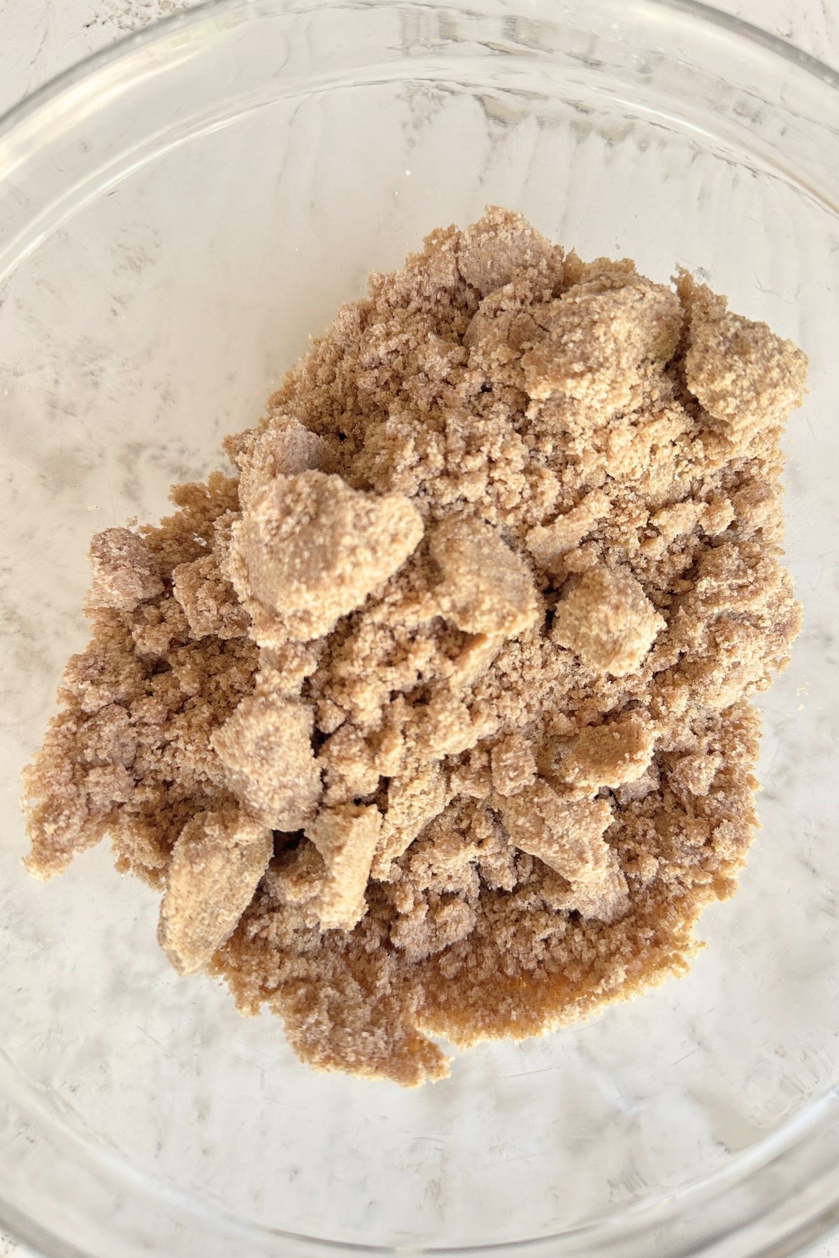 Butter and vanilla mixed into the dry mixture to form coarse, clumpy crumbs.