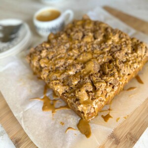 Pumpkin coffee cake with coffee glaze on parchment paper, ready to slice and eat.