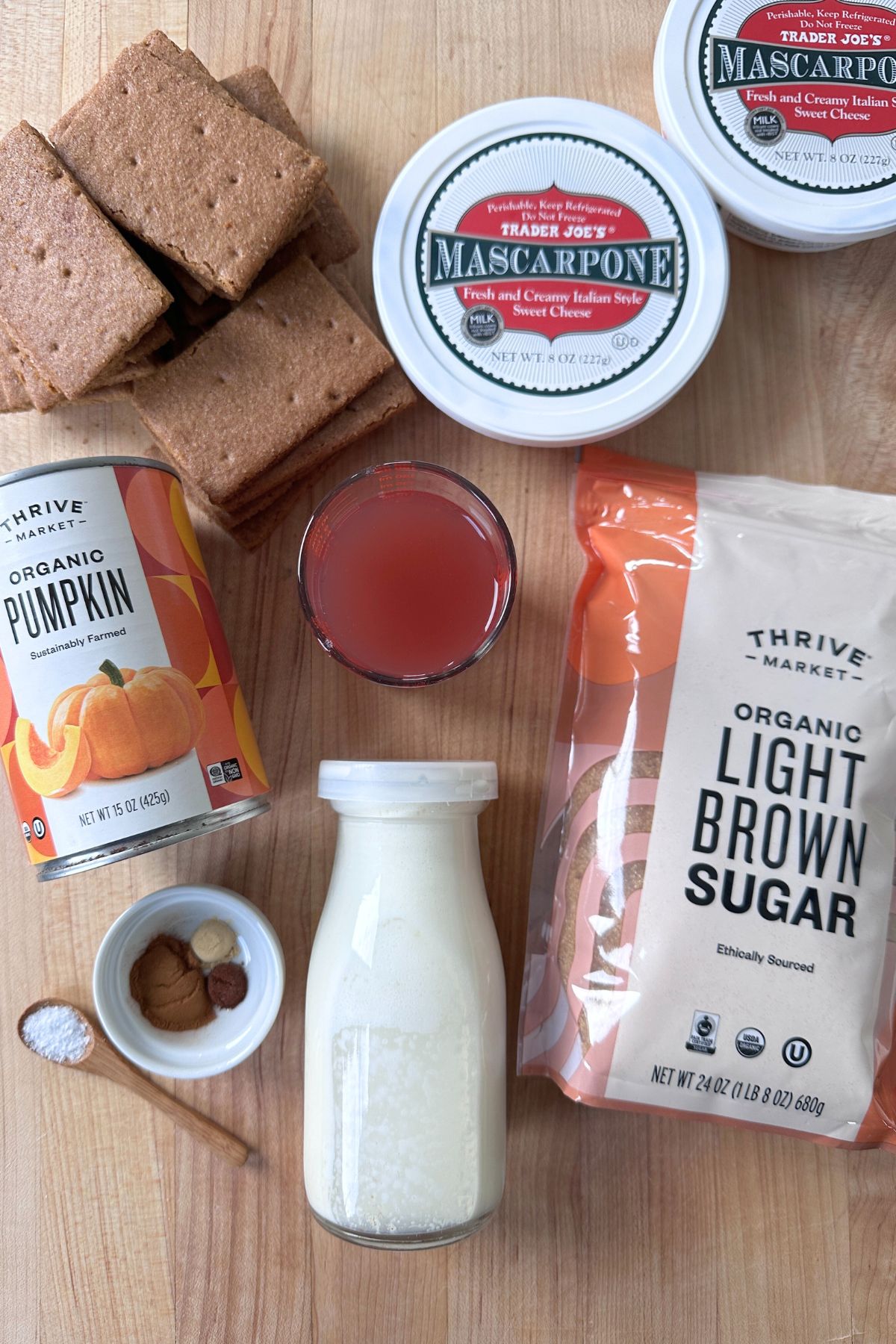 Ingredients for pumpkin icebox cake including cinnamon graham crackers, Mascarpone cheese, organic pumpkin butter, light brown sugar, spices, and heavy cream.