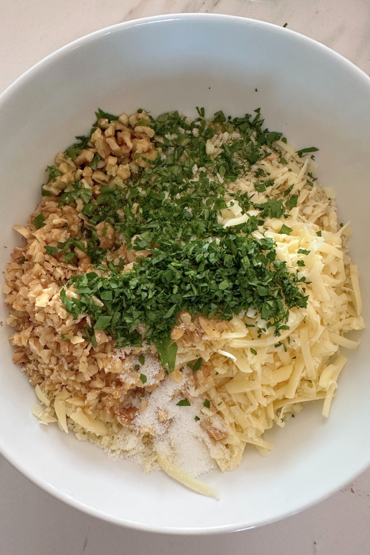 A medium white bowl with the filling ingredients ready to mix.