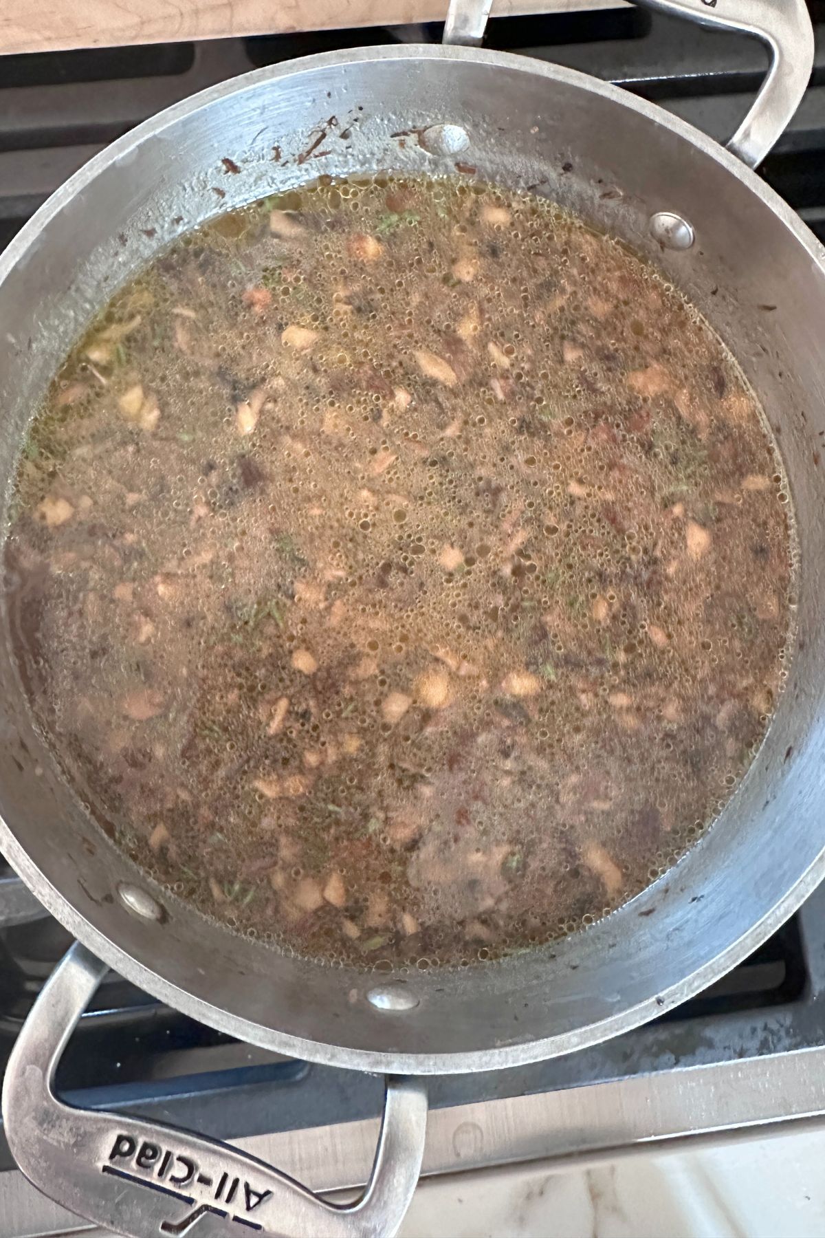A large pot on the stove with vegan mushroom gravy ingredients in it. 