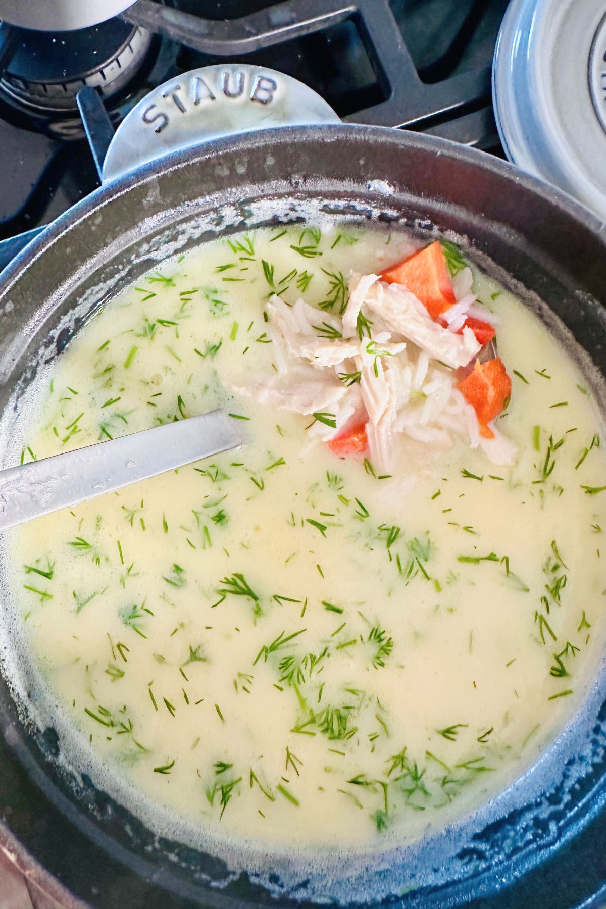 Soup pot with tempered mixture added to the broth along with cooked rice and shredded turkey.